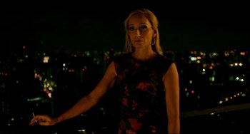 Movie still from “Only God Forgives” (2013), directed by Nicolas Winding Refn – A woman standing in front of a city at night; Medium shot, Over the shoulder angle