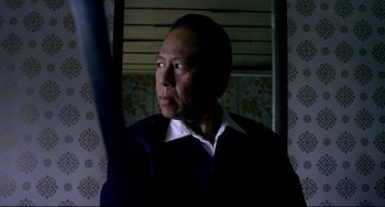 Movie still from “Only God Forgives” (2013), directed by Nicolas Winding Refn – A man in a dark room looking into the distance; Close Up shot, Low angle