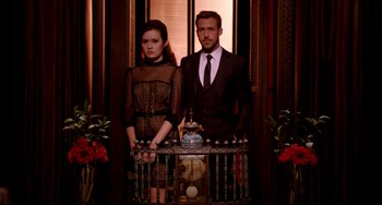 Movie still from “Only God Forgives” (2013), directed by Nicolas Winding Refn – A man and a woman standing next to each other in front of a clock; Medium shot, Low angle
