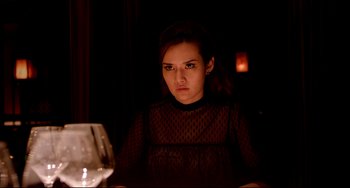 Movie still from “Only God Forgives” (2013), directed by Nicolas Winding Refn – A woman sitting in front of a computer at a table; Medium shot, Over the shoulder angle