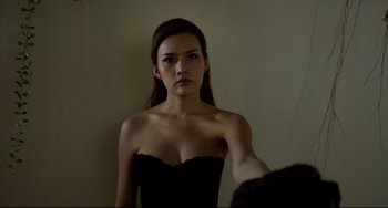 Movie still from “Only God Forgives” (2013), directed by Nicolas Winding Refn – A woman in a strapless black dress looking into a mirror; Close Up shot, Low angle