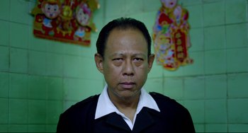 Movie still from “Only God Forgives” (2013), directed by Nicolas Winding Refn – A person wearing a black shirt; Close Up shot, Low angle