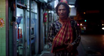 Movie still from “Only God Forgives” (2013), directed by Nicolas Winding Refn – A man standing in the street wearing a scarf; Medium shot, Low angle