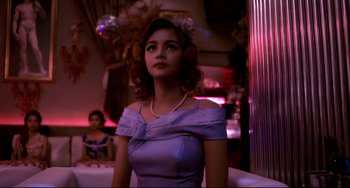 Movie still from “Only God Forgives” (2013), directed by Nicolas Winding Refn – A woman in a purple dress and a white flower in her hair; Medium shot, Low angle