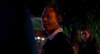 Movie still from “Only God Forgives” (2013), directed by Nicolas Winding Refn – A person wearing a suit and tie; Close Up shot, Over the shoulder angle
