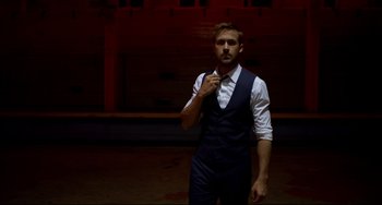 Movie still from “Only God Forgives” (2013), directed by Nicolas Winding Refn – A man in a suit and tie standing in front of a garage door; Medium shot, Low angle