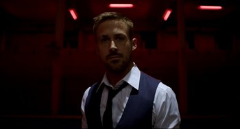 Movie still from “Only God Forgives” (2013), directed by Nicolas Winding Refn – A person wearing a vest and a tie; Close Up shot, Low angle