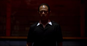 Movie still from “Only God Forgives” (2013), directed by Nicolas Winding Refn – A man wearing a black shirt and a white shirt; Medium shot, Low angle