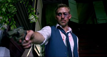 Movie still from “Only God Forgives” (2013), directed by Nicolas Winding Refn – A man in a blue vest and a white shirt is holding a knife in his hand; Medium shot, High angle