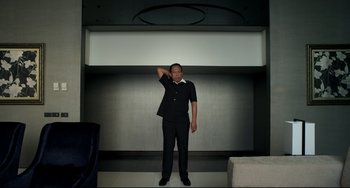 Movie still from “Only God Forgives” (2013), directed by Nicolas Winding Refn – A man standing in front of a white wall; Medium shot, Low angle