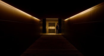 Movie still from “Only God Forgives” (2013), directed by Nicolas Winding Refn – A man standing in a dark hallway at night; Extreme Wide shot, Low angle