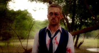 Movie still from “Only God Forgives” (2013), directed by Nicolas Winding Refn – A man with blood all over his face and neck; Medium shot, Over the shoulder angle