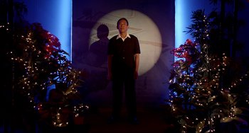 Movie still from “Only God Forgives” (2013), directed by Nicolas Winding Refn – A man standing in front of a projection of a moon; Medium shot, Low angle