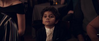 Movie still from “The Kindergarten Teacher” (2018), directed by Sara Colangelo – A boy in a suit sitting in a chair looking up; Close Up shot, Over the shoulder angle