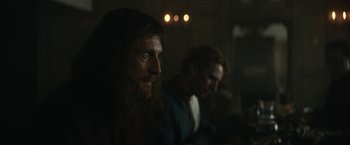 Movie still from “The King” (2019), directed by David Michôd – A man with long hair sitting next to another man with long dark hair; Close Up shot, Over the shoulder angle