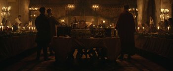 Movie still from “The King” (2019), directed by David Michôd – A group of people sitting around a table with candles lit; Wide shot, Low angle