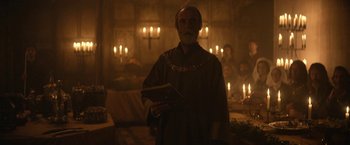 Movie still from “The King” (2019), directed by David Michôd – A man with a beard is holding a book in his hands; Medium shot, Low angle