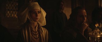 Movie still from “The King” (2019), directed by David Michôd – A woman with a head covering and a necklace; Close Up shot, Over the shoulder angle