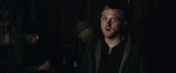 Movie still from “The King” (2019), directed by David Michôd – A man in a black jacket looking at the camera; Close Up shot, Over the shoulder angle