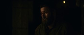 Movie still from “The King” (2019), directed by David Michôd – A man with a long beard is sitting in the dark; Close Up shot, Over the shoulder angle