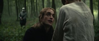 Movie still from “The King” (2019), directed by David Michôd – A man with long blonde hair is looking at another man in the woods; Close Up shot, Over the shoulder angle