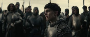 Movie still from “The King” (2019), directed by David Michôd – A man in a chain mail armor stands in front of a group of men; Close Up shot, Low angle