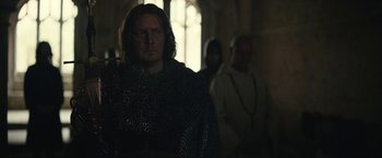 Movie still from “The King” (2019), directed by David Michôd – A man in chain mail standing next to another man in chain mail; Medium shot, Over the shoulder angle