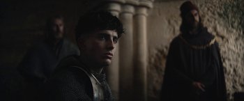 Movie still from “The King” (2019), directed by David Michôd – A young man wearing a chain mail armor; Close Up shot, Over the shoulder angle