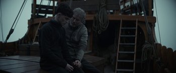 Movie still from “The King” (2019), directed by David Michôd – Two men sitting on a bench in a boat; Medium shot, Over the shoulder angle