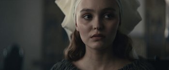 Movie still from “The King” (2019), directed by David Michôd – A woman with a white head scarf on her head; Close Up shot, Over the shoulder angle