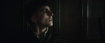 Movie still from “The King” (2019), directed by David Michôd – A young man looking up into the dark; Close Up shot, Low angle