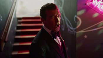 Movie still from “The Laundromat” (2019), directed by Steven Soderbergh – A man in a suit and bow tie standing in front of a staircase; Close Up shot, Low angle