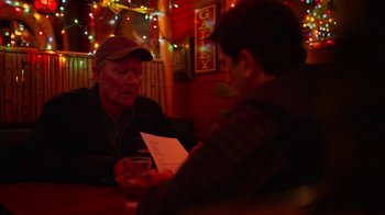 Movie still from “The Laundromat” (2019), directed by Steven Soderbergh – Two men sitting at a table in front of each other; Medium shot, Over the shoulder angle
