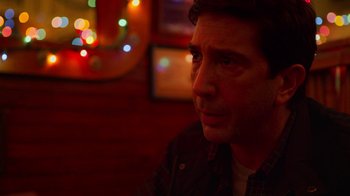 Movie still from “The Laundromat” (2019), directed by Steven Soderbergh – A person sitting at a table; Close Up shot, Low angle