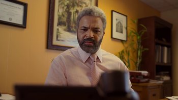 Movie still from “The Laundromat” (2019), directed by Steven Soderbergh – An older man in a pink dress shirt and tie; Medium shot, Low angle