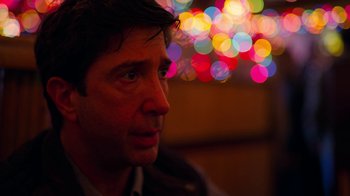 Movie still from “The Laundromat” (2019), directed by Steven Soderbergh – A person looking at the camera; Close Up shot, Over the shoulder angle