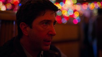 Movie still from “The Laundromat” (2019), directed by Steven Soderbergh – A person looking at the camera; Close Up shot, Over the shoulder angle