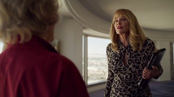 Movie still from “The Laundromat” (2019), directed by Steven Soderbergh – A woman standing next to another woman in front of a window; Medium shot, Low angle