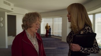 Movie still from “The Laundromat” (2019), directed by Steven Soderbergh – Two women standing next to each other in a room; Medium shot, Over the shoulder angle