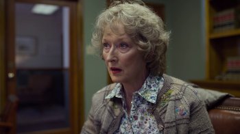 Movie still from “The Laundromat” (2019), directed by Steven Soderbergh – An older woman is looking at something in the distance; Close Up shot, Over the shoulder angle