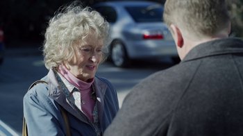 Movie still from “The Laundromat” (2019), directed by Steven Soderbergh – An older woman talking to a man in a parking lot; Close Up shot, Over the shoulder angle