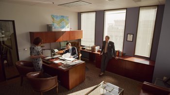 Movie still from “The Laundromat” (2019), directed by Steven Soderbergh – A man and a woman in an office setting; Wide shot, High angle