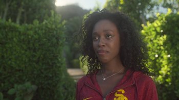 Movie still from “The Laundromat” (2019), directed by Steven Soderbergh – A young woman in a red and yellow jacket; Close Up shot, Over the shoulder angle