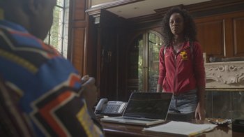 Movie still from “The Laundromat” (2019), directed by Steven Soderbergh – A woman standing in front of a laptop computer on a desk; Medium shot, Over the shoulder angle