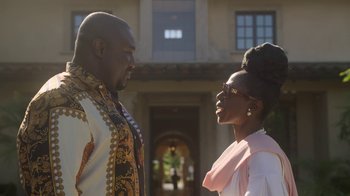 Movie still from “The Laundromat” (2019), directed by Steven Soderbergh – A man and a woman standing next to each other outside; Medium shot, Low angle