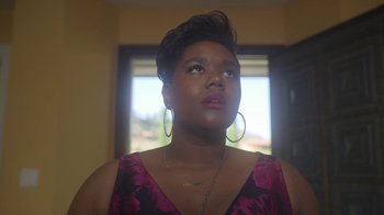 Movie still from “The Laundromat” (2019), directed by Steven Soderbergh – A woman in a pink and black dress looking up; Close Up shot, Low angle