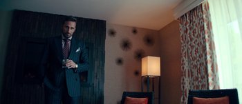 Movie still from “The Laundromat” (2019), directed by Steven Soderbergh – A man in a suit and tie in front of a mirror; Medium shot, Low angle