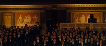 Movie still from “The Laundromat” (2019), directed by Steven Soderbergh – A group of men in suits and ties posing for a picture; Extreme Wide shot, High angle