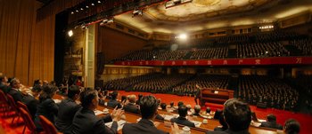 Movie still from “The Laundromat” (2019), directed by Steven Soderbergh – A group of people sitting in front of an audience; Extreme Wide shot, High angle