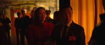 Movie still from “The Laundromat” (2019), directed by Steven Soderbergh – A man and a woman standing next to each other; Medium shot, Over the shoulder angle